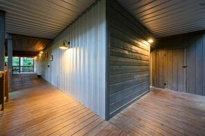 Ein Korridor mit Holzboden und Metallwänden, der zu einer Tür führt.