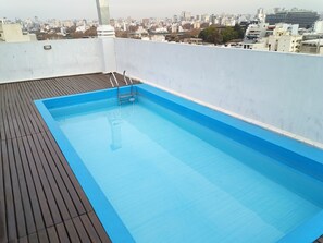 A rooftop swimming pool with a wooden deck and a cityscape view. - One apartment - A lot of beds at Palermo Hollywood - Fully equiped - ב''ה (Buenos Aires)