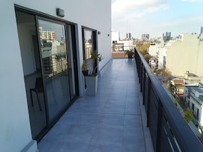 Ein Balkon mit Blick auf die Stadt, Topfpflanzen und einem Geländer.