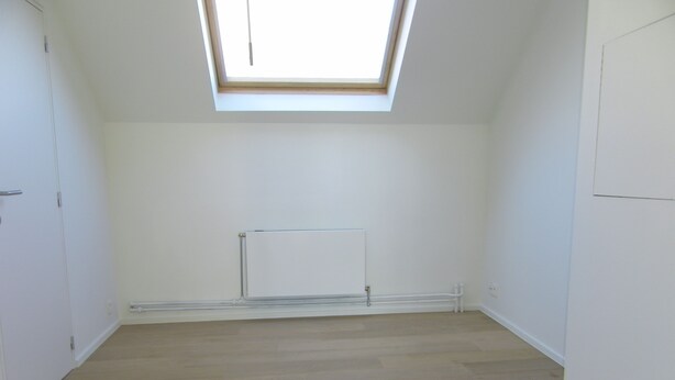 A room with a sloped ceiling, a radiator, and wooden flooring. - Abbaye de la Cambre • Private Mansion • 469 m• Lift &  AIR CO , Min 92 nights (Ixelles)