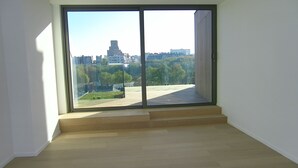 A room with a large sliding glass door leading to an outdoor terrace with a view of a cityscape. - Abbaye de la Cambre • Private Mansion • 469 m• Lift &  AIR CO , Min 92 nights (Ixelles)