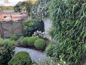 Ein Garten mit verschiedenen Pflanzen und einem Kiesweg.