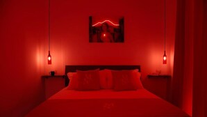 A room with a bed, two bedside tables, and a wall-mounted picture. - Mia Napoli (Naples)