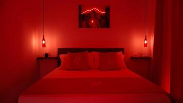 Una camera con un letto, due comodini e un quadro appeso al muro.