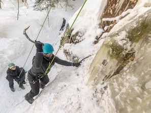 A person rappelling down a snowy slope with a rope. - Cozy stay at Haliburton Forest. Trails, Wolf Centre, Canopy Tour, 100 lakes! (Dysart and Others)