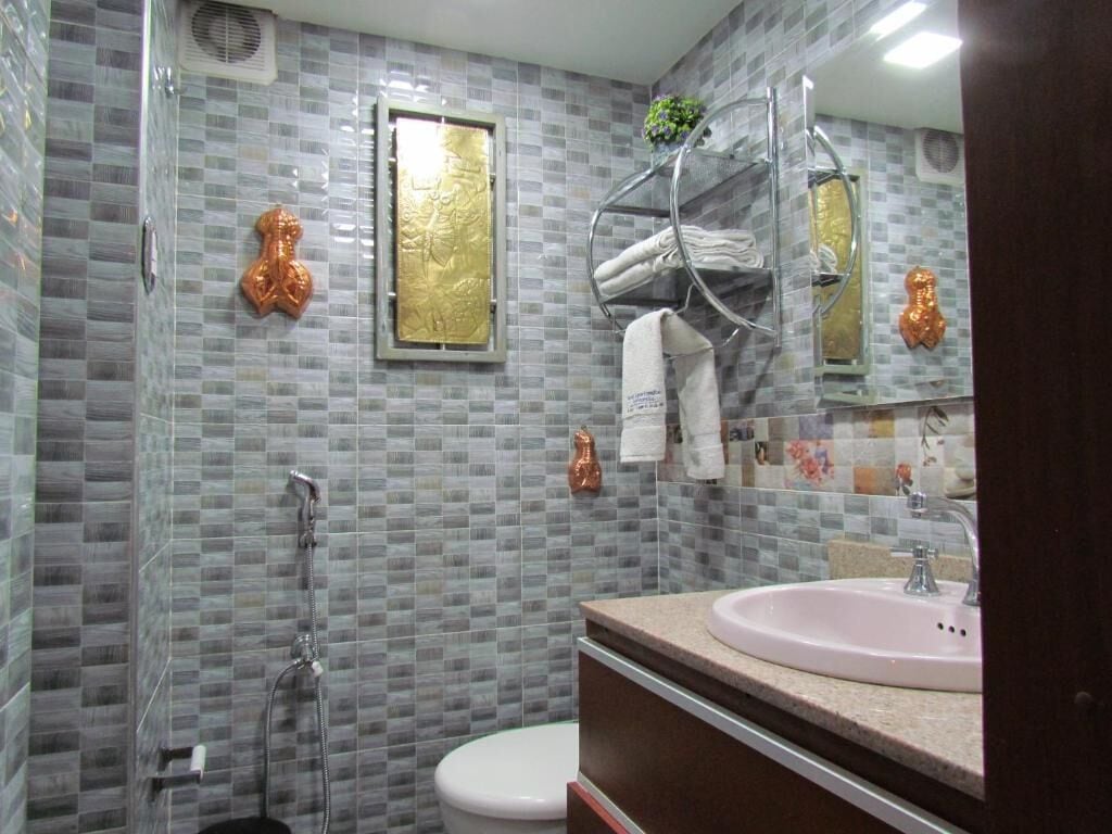 Um banheiro com chuveiro, vaso sanitário e pia.