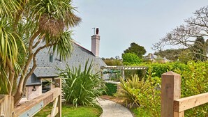 A pathway leading to a house with a sloped roof and a chimney. - Charming Cottage for 4 in Dorset (Brixham)