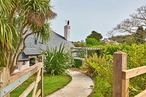 A pathway leading to a house with a sloped roof and a chimney. - Charming Cottage for 4 in Dorset (Brixham)