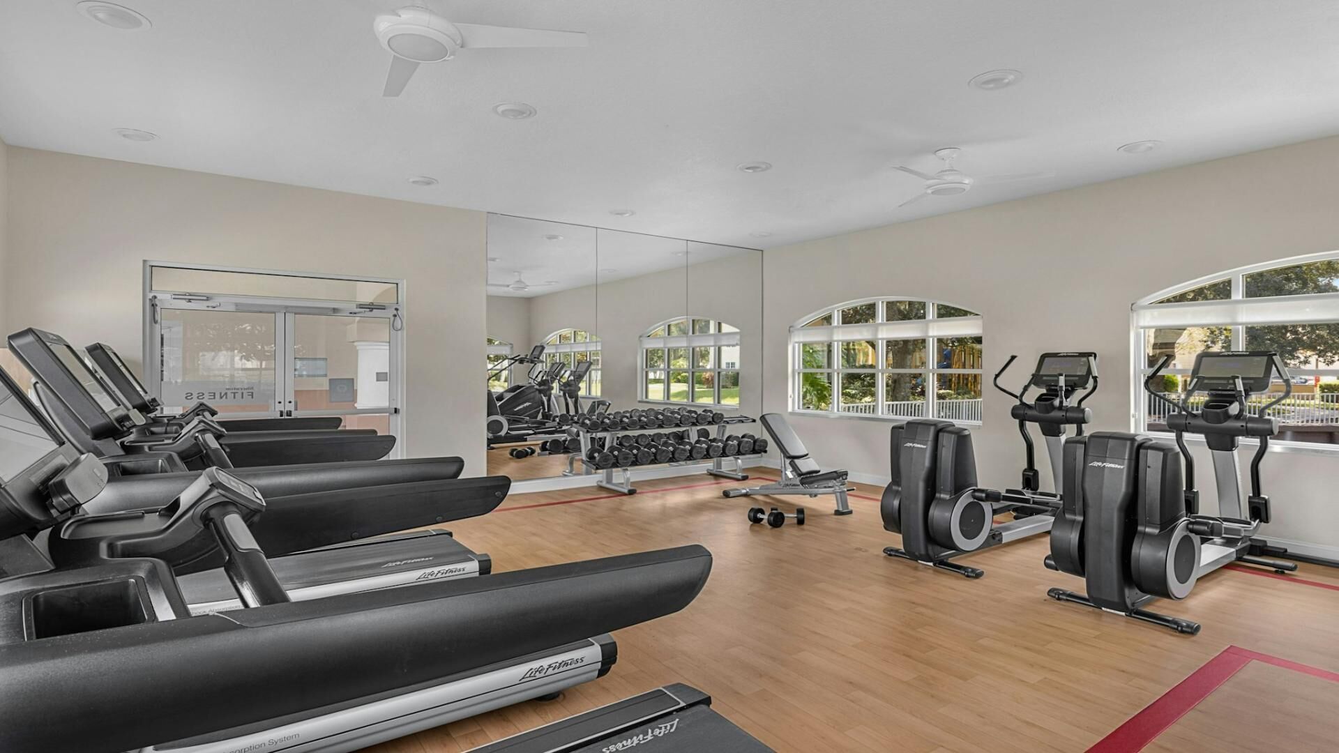 Ein modernes Fitnessstudio mit Laufbändern, Kurzhanteln und Trainingsgeräten.