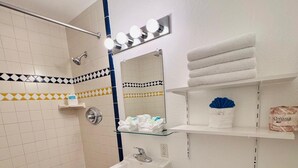 A bathroom with a shower, sink, toilet, and vanity with a mirror. - GOLDEN WEST MOTEL (Klamath Falls)