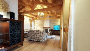 A spacious living room with a wooden ceiling, a fireplace, and a television. - Luxury Villa Le Rose: Pool, Miele Kitchen, Top-Notch Comfort, and Free Bikes! (Poreč)