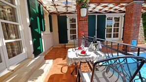 An outdoor patio with a table set for dining, a pool, and a brick wall. - Luxury Villa Le Rose: Pool, Miele Kitchen, Top-Notch Comfort, and Free Bikes! (Poreč)
