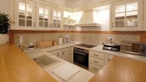 A kitchen with white cabinets, a built-in oven, a coffee maker, and a toaster. - Luxury Villa Le Rose: Pool, Miele Kitchen, Top-Notch Comfort, and Free Bikes! (Poreč)