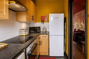 A compact kitchen with a microwave, toaster, and refrigerator.