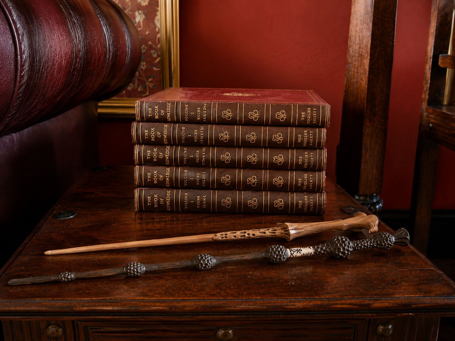 Un montón de libros sobre una mesa de madera, con una silla de madera al fondo.