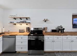 A modern kitchen with white cabinetry, a stainless steel stove, and wooden countertops. - Cozy Mountains Retreat w/ Pool-Near Medicine Park & Wichita Mtns - 6091 Pisang (Lawton)