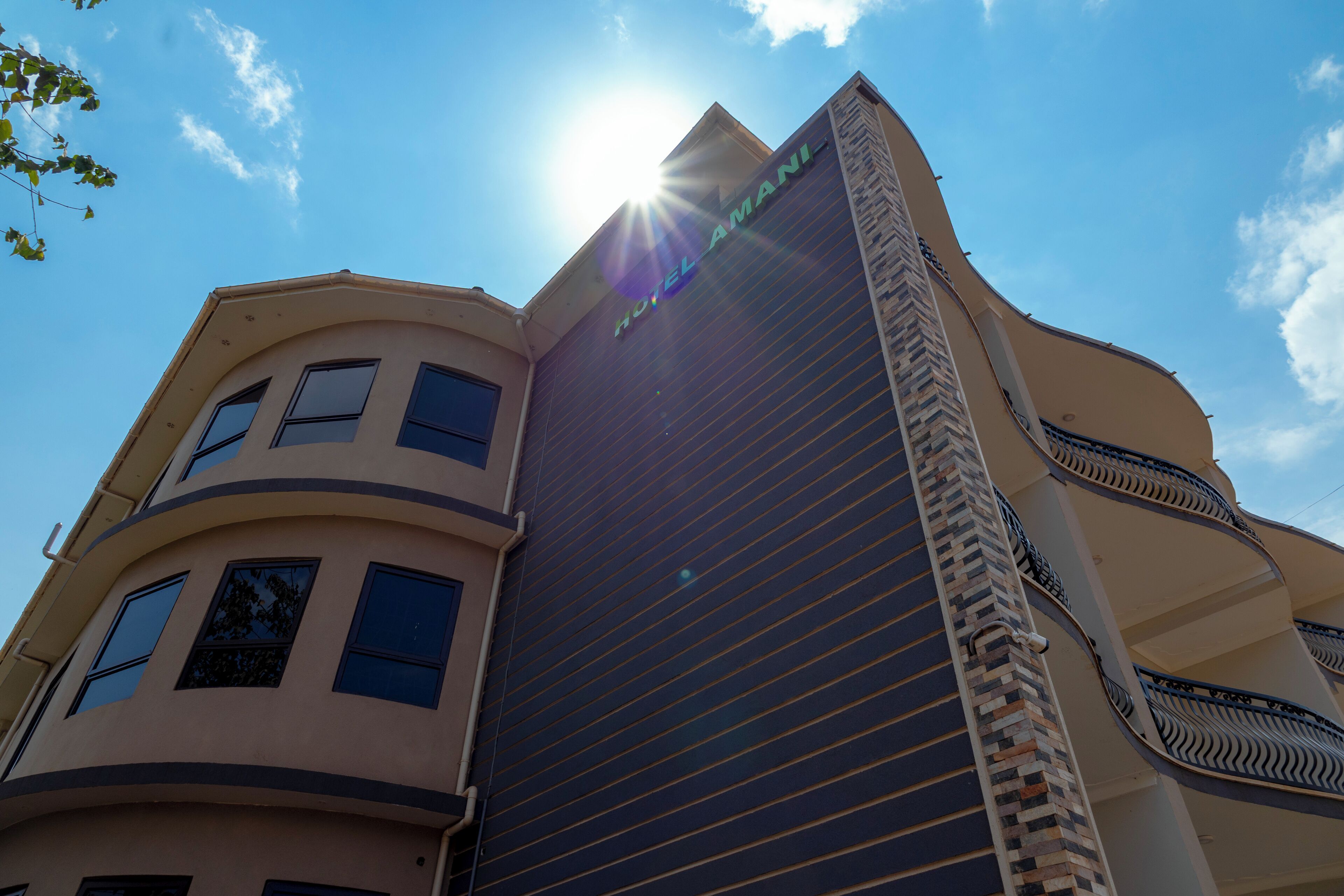 A hotel building with a modern architectural design, featuring a prominent 'HOTEL' sign on the facade.