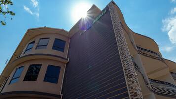 A hotel building with a modern architectural design, featuring a prominent 'HOTEL' sign on the facade.
