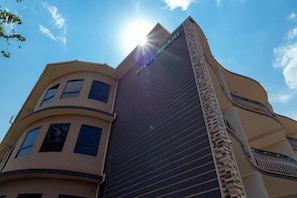 A hotel building with a modern architectural design, featuring a prominent 'HOTEL' sign on the facade.