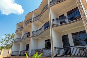 A multi-story building with balconies, windows, and a clear sky.
