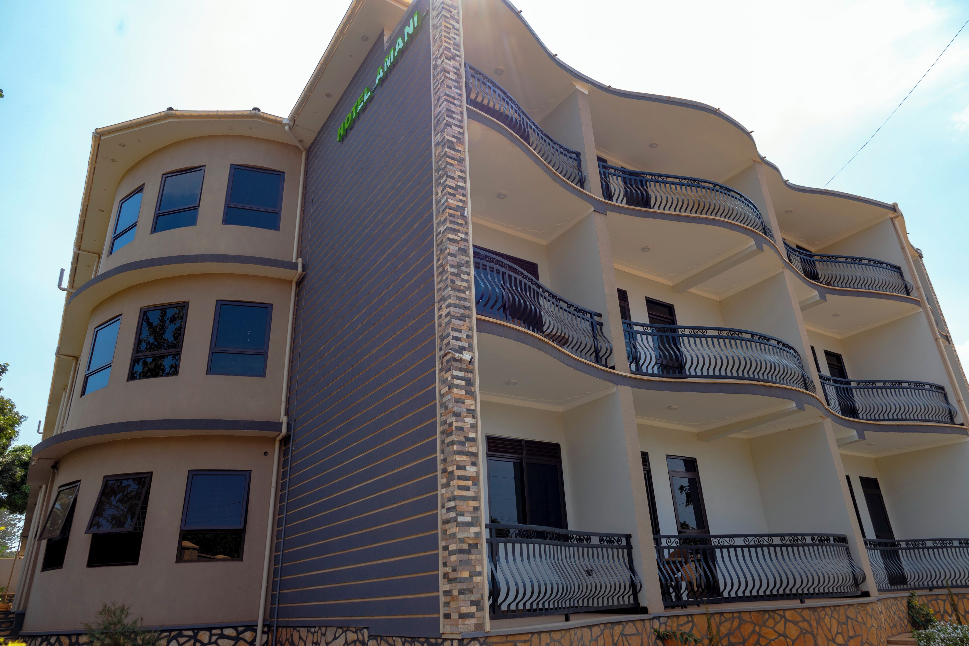 A multi-story hotel with balconies, a curved facade, and a sign indicating it is a hotel.