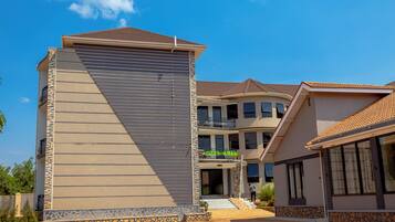 A multi-story hotel with a modern design, featuring a prominent vertical structure and a covered entrance.