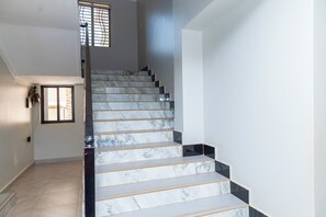 A staircase with marble steps and a handrail, leading to an upper floor.