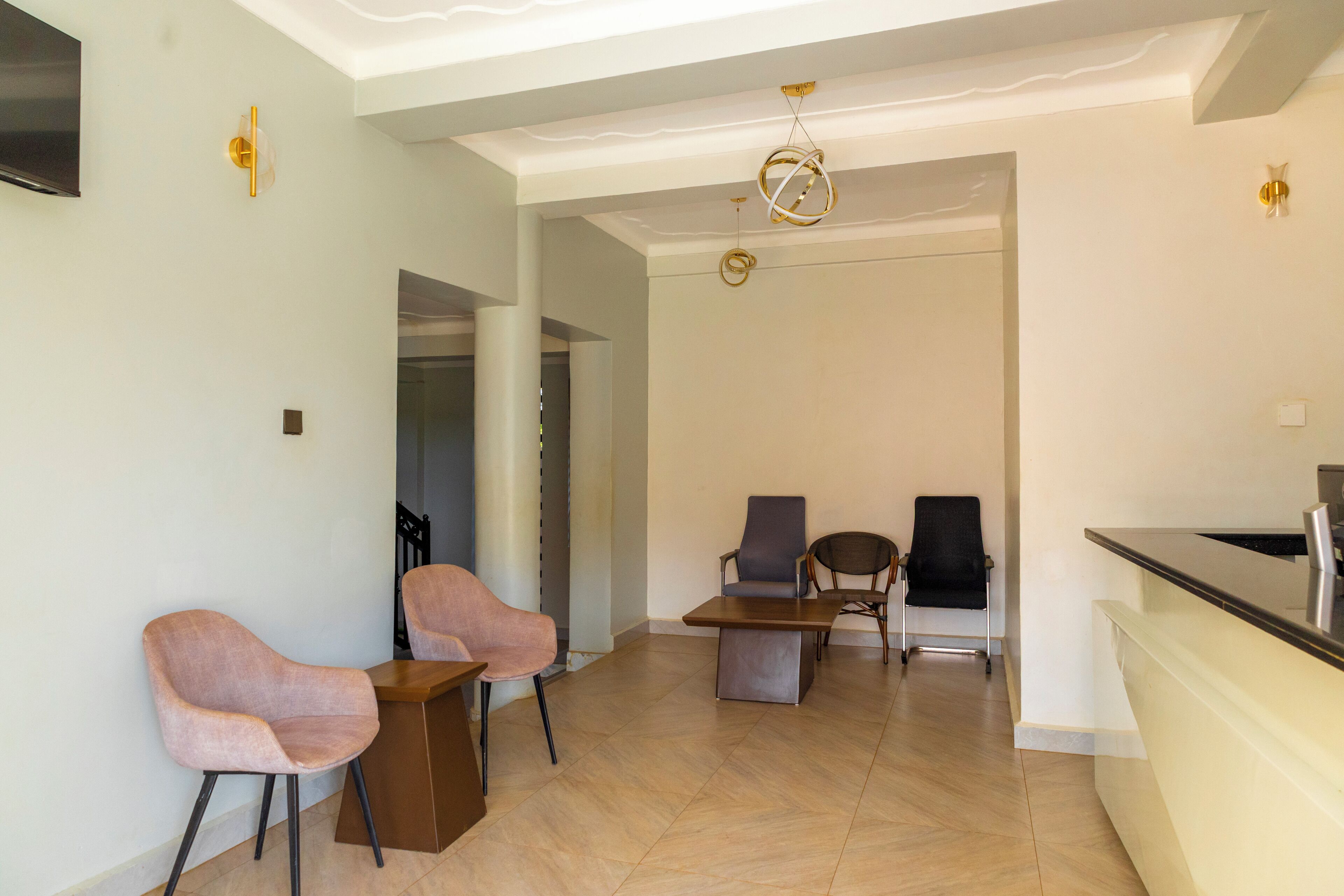 Amplia sala de estar con mostrador de cocina, dos sillones, un sofá y una mesa de comedor.