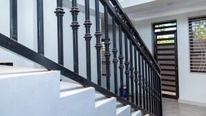 A staircase with black balusters and white risers. - Hotel Amani Limited (Jinja)
