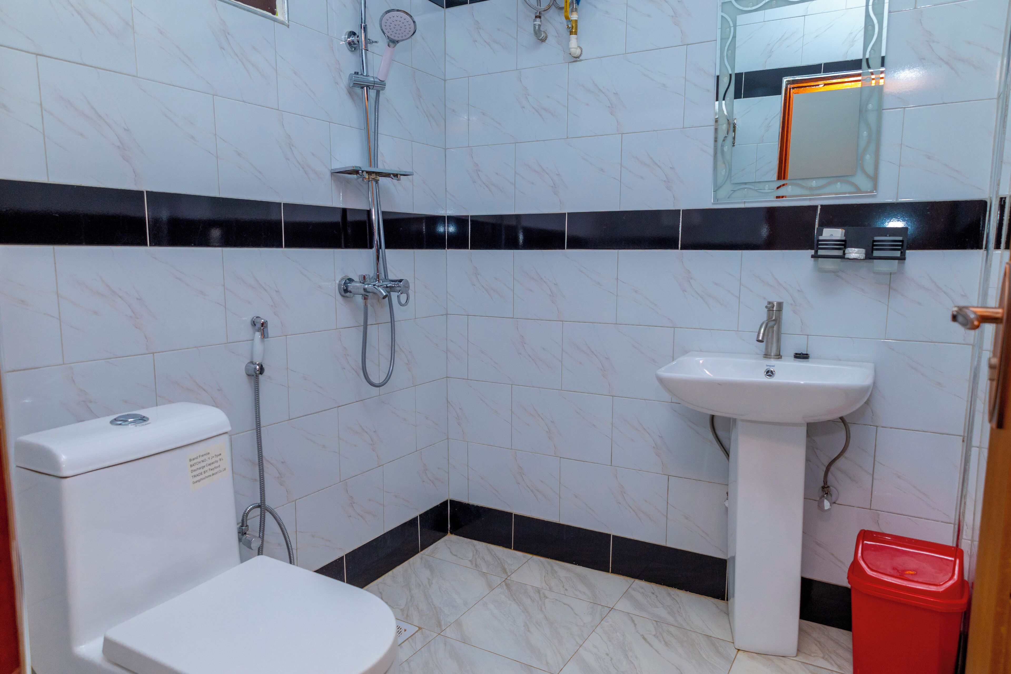 A bathroom with a toilet, sink, and shower.