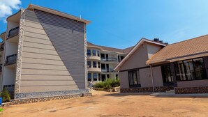 A multi-story residential building with a flat roof and a balcony. - Hotel Amani Limited (Jinja)