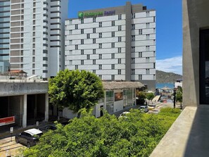 Ein Holiday Inn Resort Gebäude mit modernem Design, einem sichtbaren Schild und Blick auf die Umgebung, einschließlich eines Baumes und weiterer Gebäude.