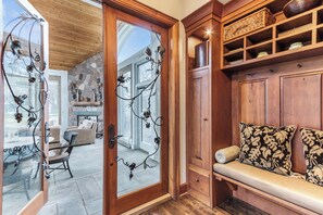 A wooden interior with a stone fireplace, a bench with patterned cushions, and a wicker shelf. - Stunning Custom Designed 10,000 sq' Estate Home.
Tranquil Views of Private Lake. (Lake Geneva)