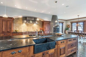A spacious kitchen with a large island, built-in appliances, and a stone backsplash. - Stunning Custom Designed 10,000 sq' Estate Home.
Tranquil Views of Private Lake. (Lake Geneva)