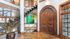 A spacious interior with a wooden door, a staircase, and a potted plant. - Stunning Custom Designed 10,000 sq' Estate Home.
Tranquil Views of Private Lake. (Lake Geneva)