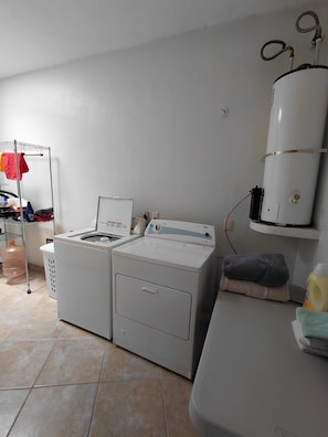 A laundry area with a washing machine, dryer, and a water heater. - Beautiful 2 BR in El Dorado with gorgeous views! (Jal.)