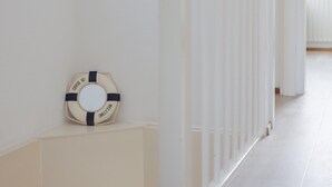 Ein Flur mit weißer Wand und einem Rettungsring mit der Aufschrift 'WELCOME'.