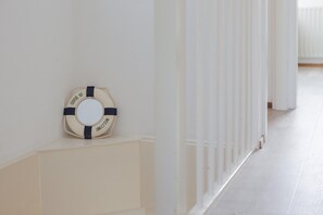 Ein Flur mit weißer Wand und einem Rettungsring mit der Aufschrift 'WELCOME'.