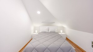 A bedroom with a bed, two bedside tables, and a ceiling light. - Tony's House B by YOUR KEY (Santana)