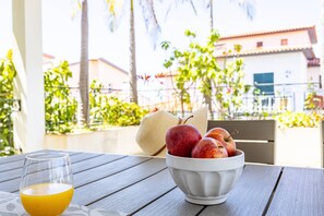 A table with a glass of orange juice and a bowl of apples. - Villa Palmeiras by YOUR KEY (Funchal)