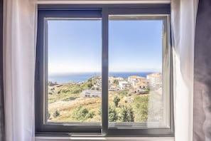 A window with a view of a coastal town and the sea. - Vista Mar À Costa by YOUR KEY (Santa Cruz)