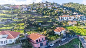 A hillside residential area with terraced vineyards, houses with red-tiled roofs, and a parking area. - Vivenda Paz Lobo by Your Key (Santa Cruz)