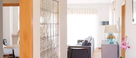 A modern living room with a sofa, a small table, and a lamp.