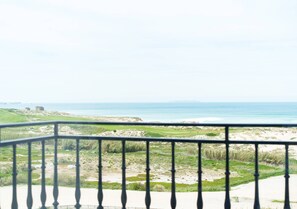 A coastal landscape with a grassy area, a sandy beach, and the ocean in the distance. - Horizon Retreat, Sea View A12 (Óbidos)