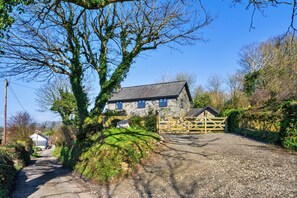 A stone house with a gravel driveway and a wooden gate. - Luxury Lodge With Hot Tub (Camelford)