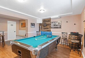 A pool table with cues and balls, a dartboard, and a bar area with stools and a barrel. - Lake Front! Hot Tub, Fire Pits, Game Room (East Stroudsburg)
