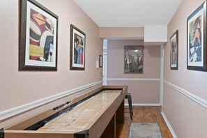 A hallway with framed artwork on the walls, a pool table, and a carpeted floor. - Lake Front! Hot Tub, Fire Pits, Game Room (East Stroudsburg)