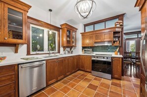A kitchen with wooden cabinets, a stainless steel dishwasher, a stove, and a window.