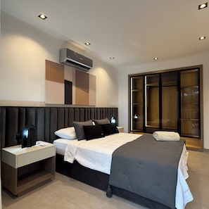 Un dormitorio moderno con cama, mesitas de noche, un equipo de aire acondicionado y una puerta corrediza de vidrio.