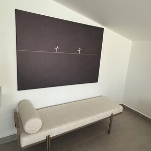 A room with a large black artwork on the wall, a bench with a cushion, and a tiled floor. - Luxury Renovated New Villa in the heart of Kalkan (ANTALYA)